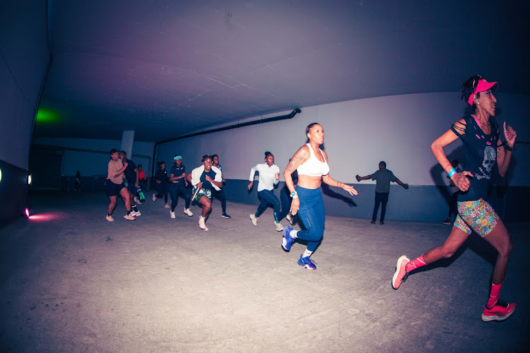 Attendees running the track course inside the building during the Nike Well Festival in Newtown.