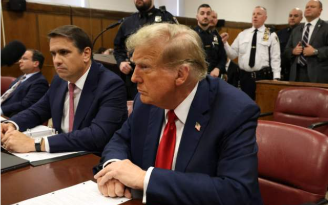 Donald Trump seated next to his attorney Todd Blanche