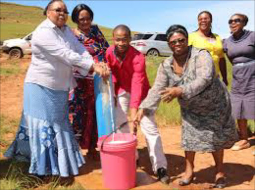 AT LONG LAST: Alfred Nzo district municipality mayor Eunice Diko and Umzimvubu local municipality mayor Khulukazi Phangwa help Mount Frere villager Olwethu Mvuzani draw water from one of new taps installed at Qwidlana village while other officials look on Picture: SUPPLIED