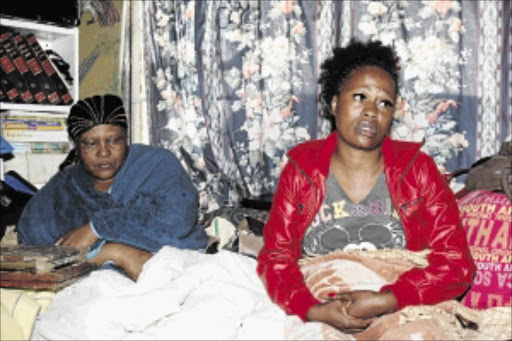 grieving: Jeanett Legalamitlwa and Fikile Khoza mourn the deaths of their relatives, Samson Phiri and Johanna Mthethwa and their two children, Frank and Angel Mthethwa, who died after eating poisonous mushrooms PHOTO: ANTONIO MUCHAVE