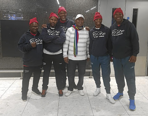 Champion Zolani Tete, second from right, and his team were met at their hotel by SA ambassador Ahlangene Sigcawu (white top).