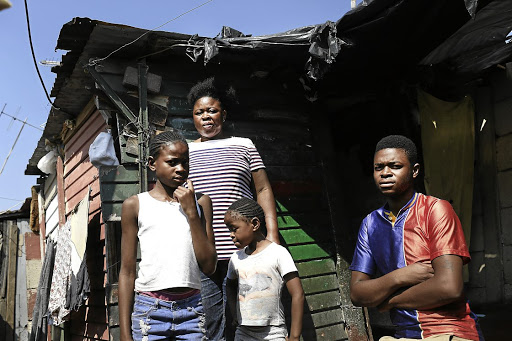 From left, Khanyisa, Solani, Victoria and Songayi Dave Rivele outside their small shack in Alex, Johannesburg. Solani has her sights set on a plot in Waterfall.