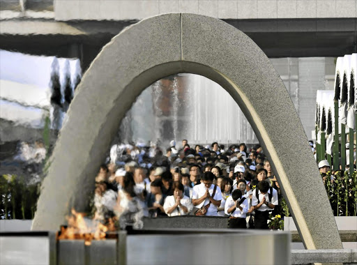 People pray in front of the cenotaph for the victims of the 1945 atomic bombing of Hiroshima at the Peace Memorial Park in the city, in western Japan, on August 6 last year, the anniversary of the bombing.