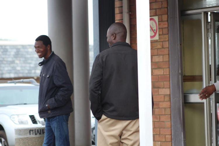 Alleged rhino poacher Muntogokwakhe Khoza turns his back to avoid being photographed while leaving the Richards Bay Magistrates Court earlier this month. Pictured with him is co-accused Ayanda Buthelezi.
