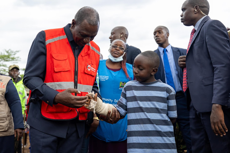 President William Ruto interacts with a boy affected by the Mai Mahiu landslide victims on April 30, 2024.