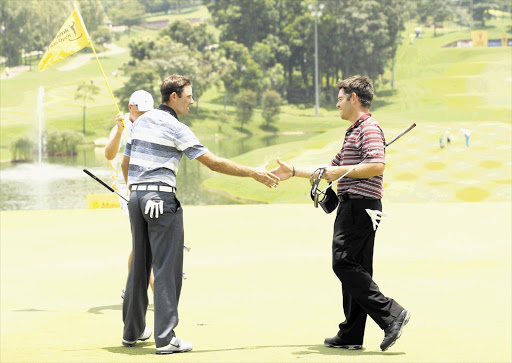 Charl Schwartzel and Louis Oosthuizen on the ninth hole for the first round of the Maybank Malaysian Open at Kuala Lumpur Golf and Country Club yesterday