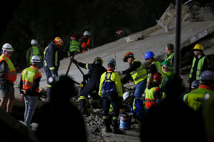 Rescue workers continue to scour the rubble of the collapsed building in Victoria Street on Wednesday night