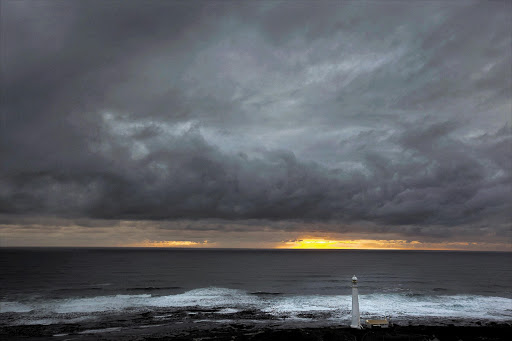 Heavy storm clouds hang threateningly over the Slangkop Lighthouse, at Kommetjie, near Cape Town. File photo.