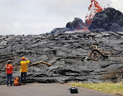 Sarah Conway, left, and Matt Patrick, both from USGS Hawaiian Volcano, observe lava erupting from a fissure in the Leilani Estates near Pahoa, Hawaii. 