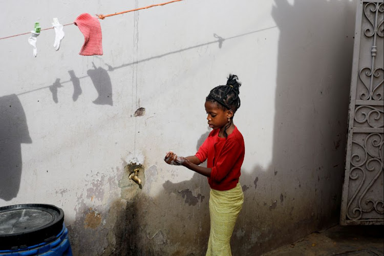 A girl washes her hands at the entrance of her parents' house in Pikine, on the outskirts of Dakar, Senegal, on March 9 2020.