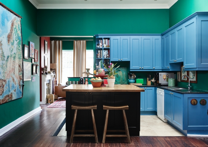 A simple white kitchen transformed into a happy space by painting the cabinets and walls in saturated blues and greens.