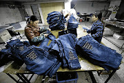 Workers sew in Xintang, Guangdong, in China. The town, nicknamed 'the denim jeans centre of the world', claims to make 60% of all jeans.
