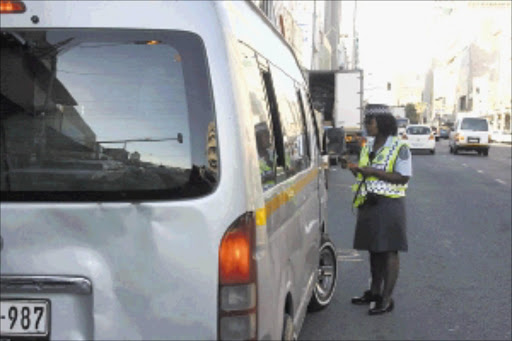 THE MINIBUS STOPS HERE: A minibus taxi operator is stopped by a Durban Metro Police officer on West Street in the city centre. Pic: Thuli Dlamini. © Sowetan