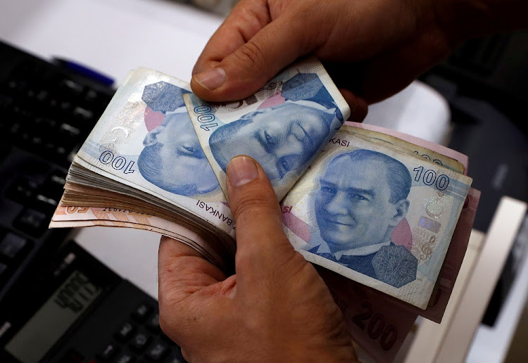 A money changer counts Turkish lira banknotes. Picture: REUTERS/MURAD SEZER