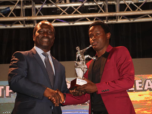 Goldon Oluoch awards Erick Ouma for the new player of the year.PHOTO/PHILIP KAMAKYA
