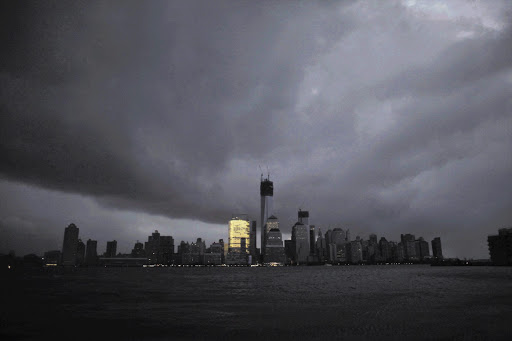 Lower Manhattan is plunged into darkness by a planned power outage as the giant storm Sandy descends on New York.