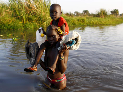 Children cross a body of water to reach a registration area prior to a food distribution carried out by the United Nations World Food Programme (WFP) in Thonyor, Leer state, South Sudan, February 25, 2017. /REUTERS