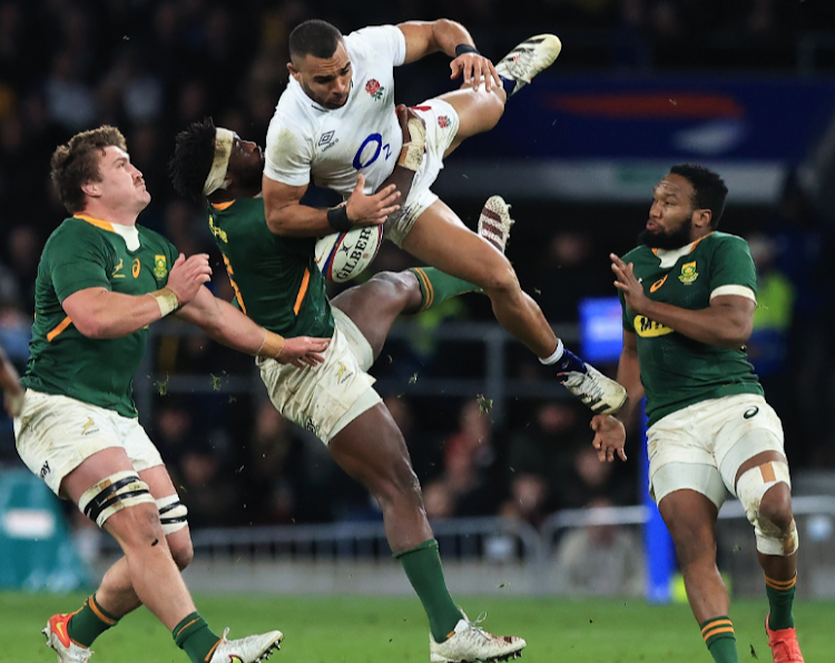 Joe Marchant of England is tackled in the air by the Springboks' Siya Kolisi. The tackle earned the Bok captain a yellow card at Twickenham.