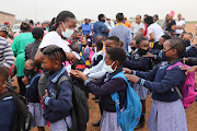 A teacher sanitises the hands of pupils as they line up for the first day of school on January 12 2022, at Setlabotjha Primary in Sebokeng.
