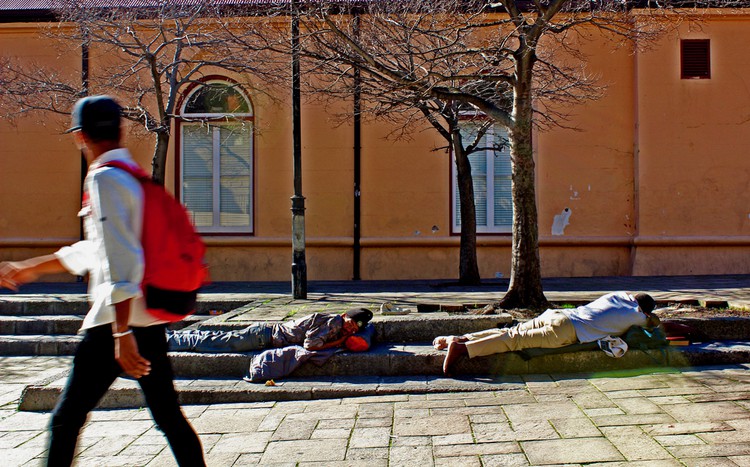 Two men sleep on the pavement outside the College of Cape Town.