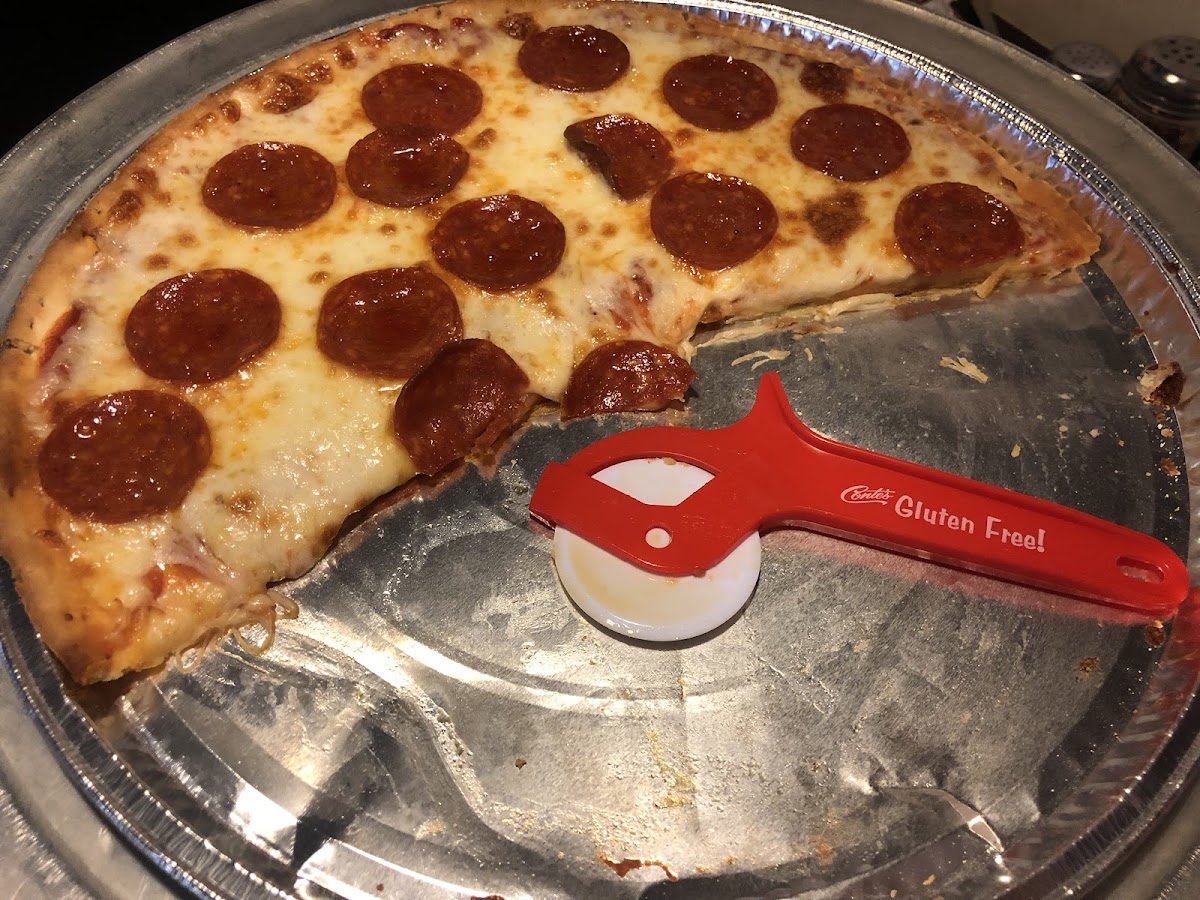 Gluten free pizza served on its own pie pan and an individually wrapped plastic pizza cutter that we got to take home!