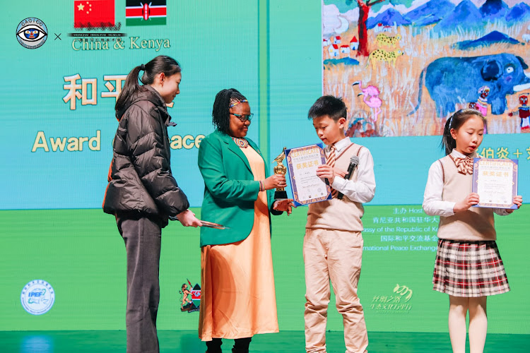 Minister Counselor Rebecca Ekuam awards a participant of the China-Africa Children International Competition in Shanghai on Tuesday, January 23, 2024