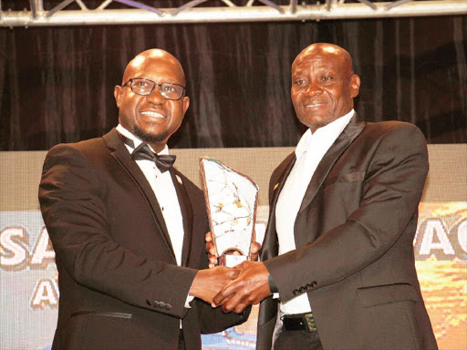 Paul Nkata receives the Coach of the year award from Sport Pesa’s Kester Shimonyo. /PHILIP KAMAKYA