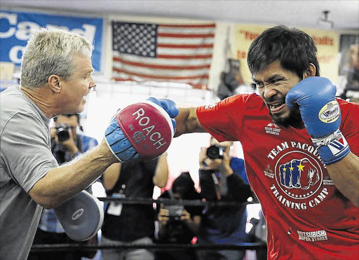 Manny Pacquiao, right, works out with his trainer Freddie Roach