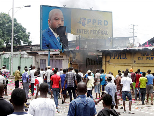 Congolese opposition supporters chant slogans as they destroy the billboard of President Joseph Kabila during a march to press the President to step down in the Democratic Republic of Congo's capital Kinshasa, September 19, 2016 /REUTERS