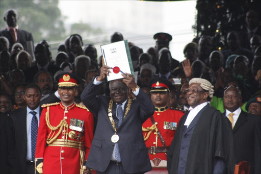 President Mwai Kibaki displays the new Constitution during its promulgation at Uhuru Park on August 10, 2010