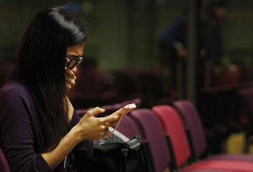 A Malaysian woman who had a relative on board the Malaysian Airlines MH17 reacts to messages on her mobile phone as she waits to travel to Kuala Lumpur International Airport from Singapore's Changi Airport. Photo credit: Reuters