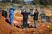 Family members gather to bury a loved one at Cambrian Cemetery in Ekurhuleni on Tuesday.