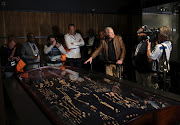 Professor Lee Berger (2nd R) gestures during an exhibit of the largest collection of fossils of close human relatives ever to go on public display in South Africa, at an area named 