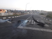 Tyres burn on the corner of Oscar Mpetha Road and Bayden Powell Drive in Cape Town on Tuesday, on the eve of the elections.