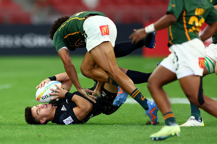 Tepaea Savage of New Zealand is tackled by Sebastiaan Jobb of South Africa in their pool match of the HSBC Singapore Rugby Sevens at the National Stadium in Singapore on April 8 2023.