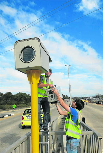 BEADY EYE: Gavin Hetherington of Truvelo and colleague Fanie Hartzenberg erect one of three law enforcement cameras along the new Gonubie Main Road Picture: MIKE LOEWE