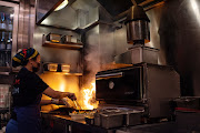 A chef prepares takeout dinner orders inside the kitchen of Chom Chom restaurant, closed to dine-in service due to Covid-19 restrictions, in Hong Kong, China, on Thursday, February 10, 2022. 