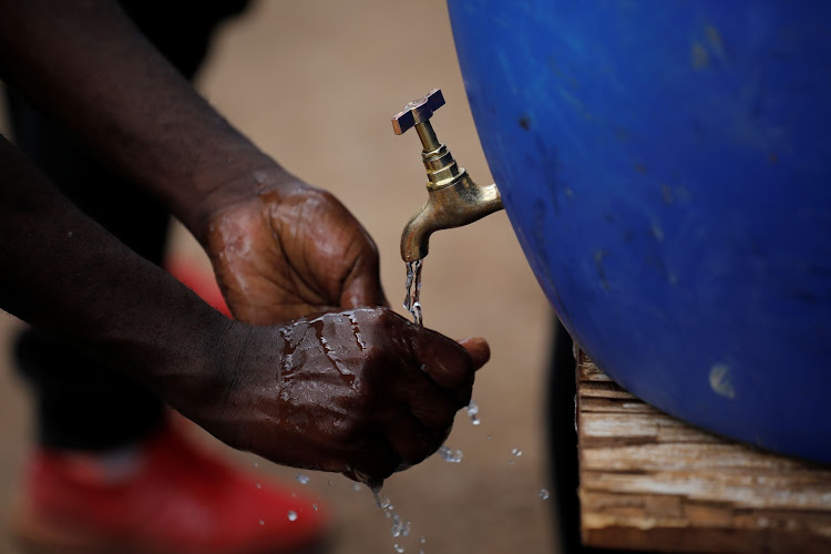 A man washes his hands against the spread of the coronavirus disease (COVID-19) at a hand washing station set up by community organisation Shining Hope for Communities (SHOFCO) in the Kibera slum in Nairobi./REUTERS