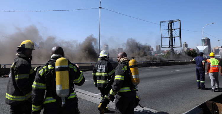 EMS crew members work to contain the underground fire in the M1 tunnel.