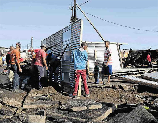 NEW START: The community in C-Section in Duncan Village rebuild shacks yesterday after a fire destroyed around 20 shacks on Tuesday night Picture: ALAN EASON