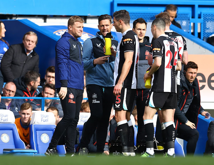 Newcastle United manager Eddie Howe and assistant manager Jason Tindall talk to Fabian Schar