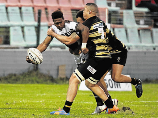 TIGHT PLAY: The Border Bulldog’s Sonwabiso Mqalo tries to pass the ball while being tackled by Boland Kavaliers player Ludio Williams, number seven, and another Kavaliers player at the BCM Stadium on Saturday Picture: ALAN EASON