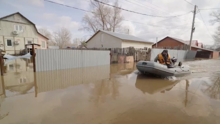 A man rides a boat in a flooded street in Orenburg, Russia, in this still image taken from video released April 8 2024. Picture: MAYOR OR ORENBERG/REUTERS