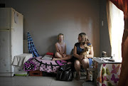 BEDSIT: Susan Cloete, whose mother is burn victim Susan van Rooyen, with her daughter Charissa in their modest home in Randfontein. / Times LIVE