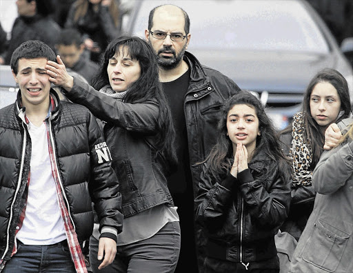 Relatives of slain children leave the Ozar Hatorah Jewish school, in Toulouse, France, yesterday, after a man on a motorbike fired on and killed three pupils Picture: REUTERS