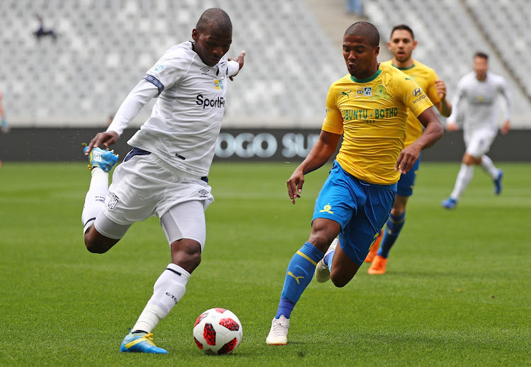 Cape Town City captain Thamsanqa Mkhize (L) releases a pass under the watchful eye of Mamelodi Sundowns defender Lyle Lakay during the MTN8 semifinal first leg match at Cape Town Stadium in Cape Town on August 25 2018.
