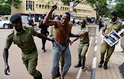 Police officers detain a Ugandan activist participating in a demonstration over proposed plans by Total Energies and the Ugandan government to build the East African Crude Oil Pipeline in Kampala, Uganda, on September 15 2023. File photo.