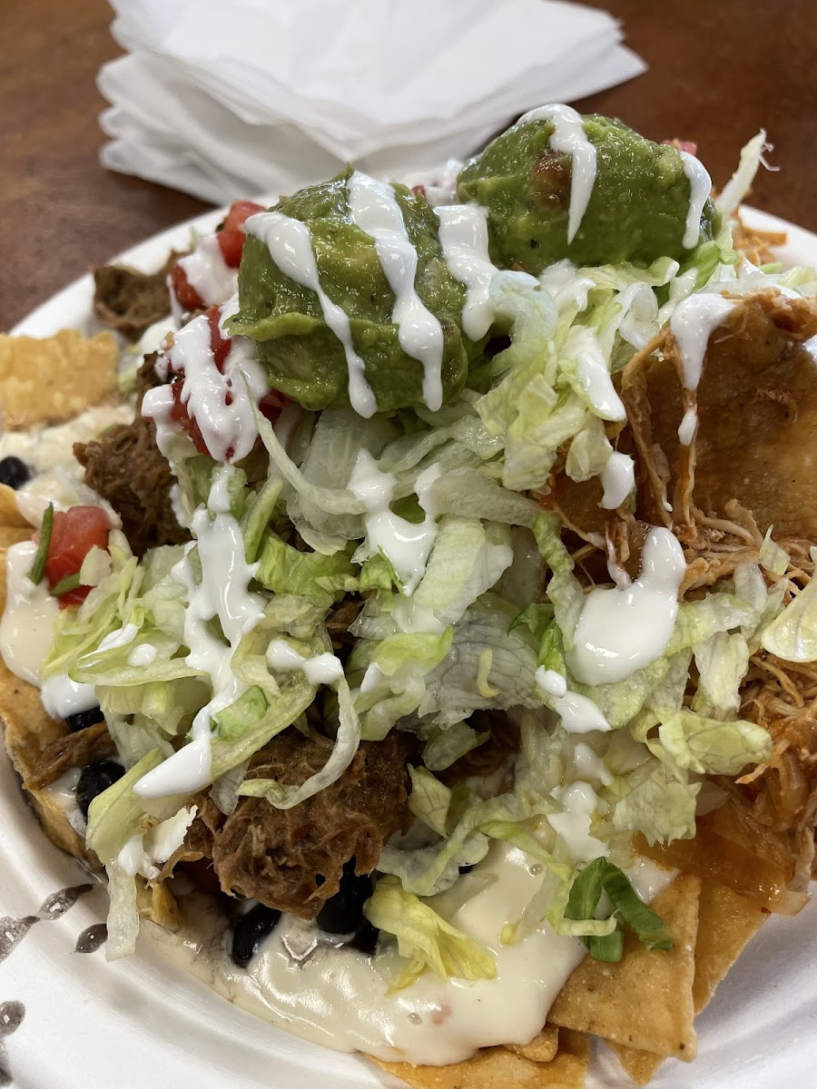 Nachos. Crispy with beans, queso, lettuce sour cream your meat choice (half barbacoa, pico, guac, and half chicken tikka and
