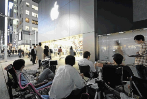 ON HOLD: Apple enthusiasts queue in front of an Apple Store in Tokyo to be the first to buy the new smartphones that will be on sale from September 19