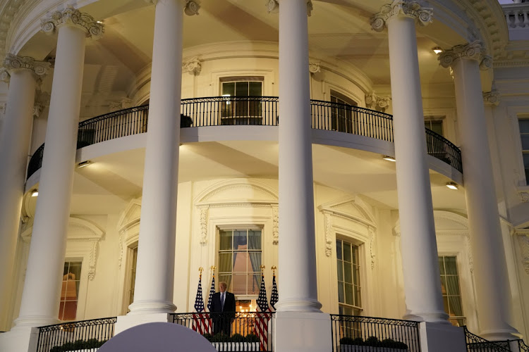 U.S. President Donald Trump poses atop the Truman Balcony of the White House after taking off his mask as he returns to the White House after being hospitalized at Walter Reed Medical Center for coronavirus disease (COVID-19), in Washington, U.S. October 5, 2020.